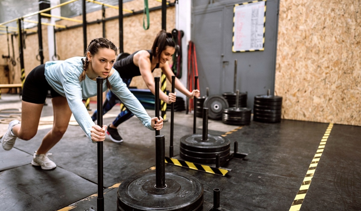 Women training with resistance bands and TRX at gym during fitness session
